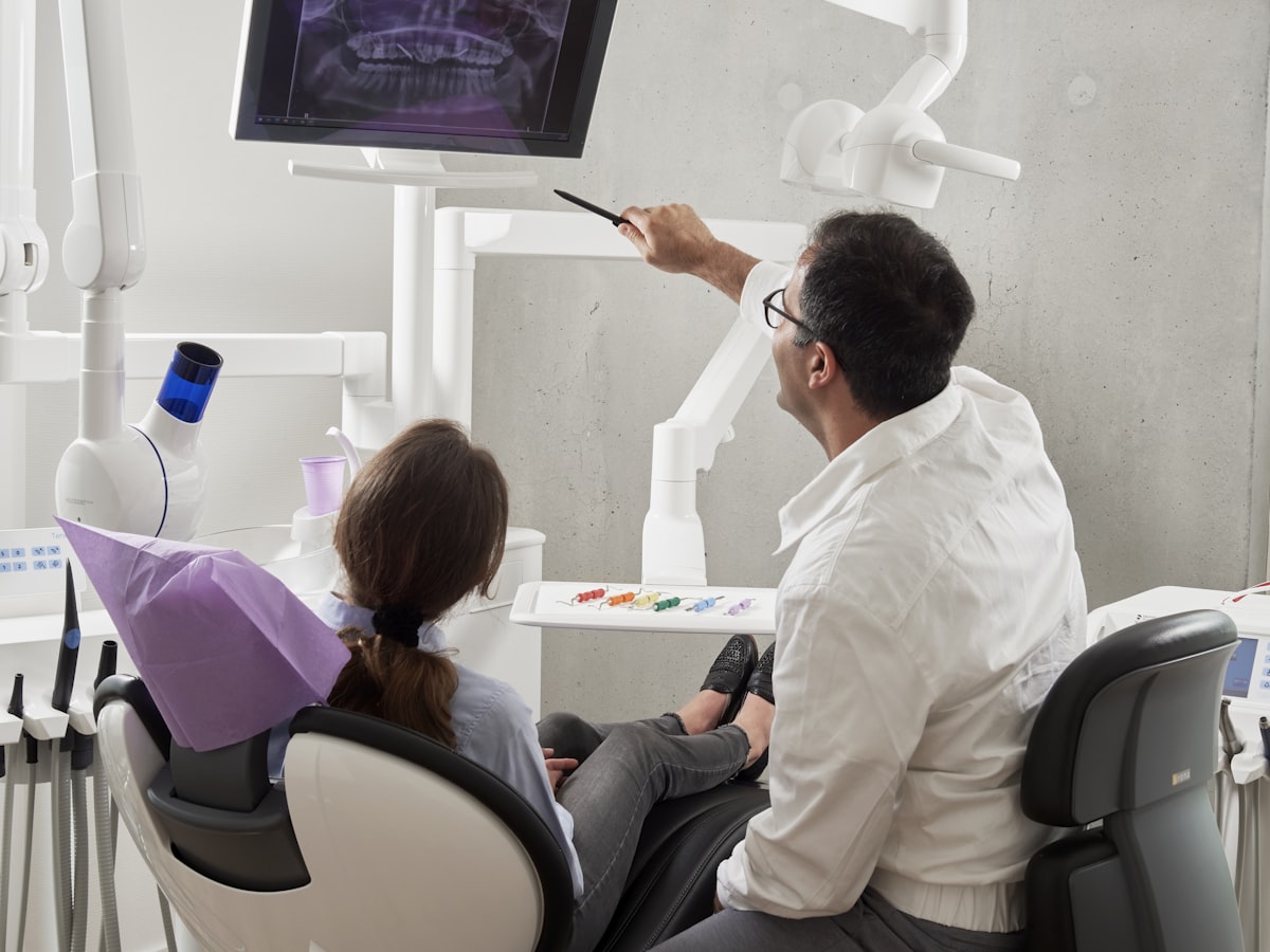 Dr. Marcelo mostrando a radiografia panorâmica para a paciente durante a consulta
